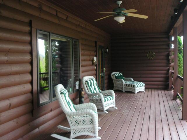 A porch with rocking chairs and a ceiling fan