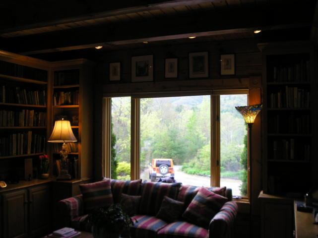 A living room with a couch and a jeep in the background
