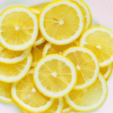 A pile of sliced lemons on a white plate