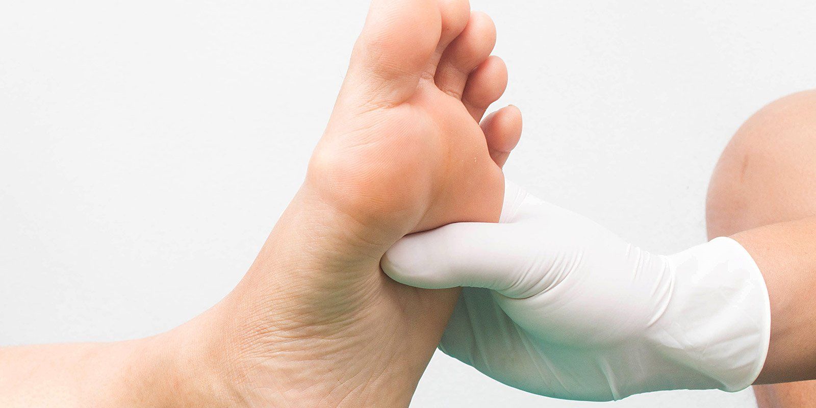 Mano massaggia pianta di un piede