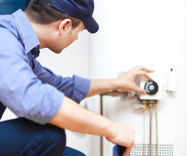 Technician Repairing A Water Heater — Baton Rouge, LA — American Plumbing Technician Repairing A Water Heater — Baton Rouge, LA — American Plumbing
