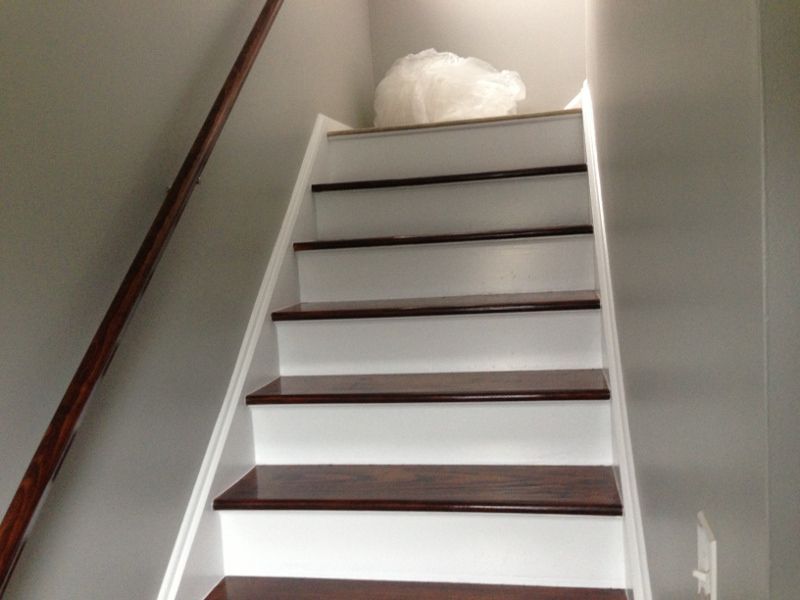 A white staircase with wooden steps and a wooden railing