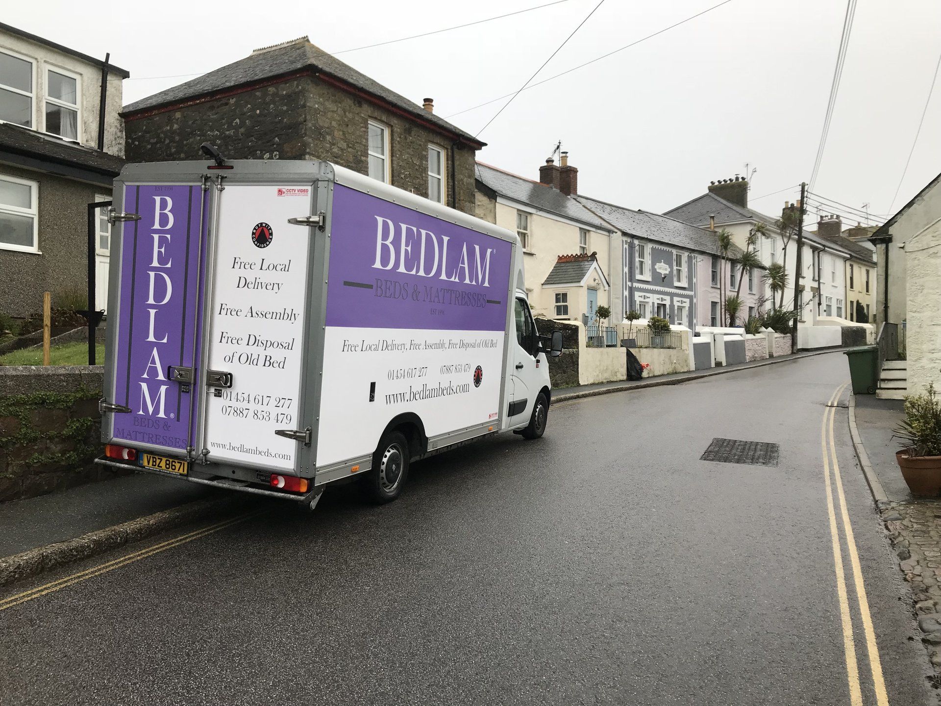 A bedlam van is driving down a residential street