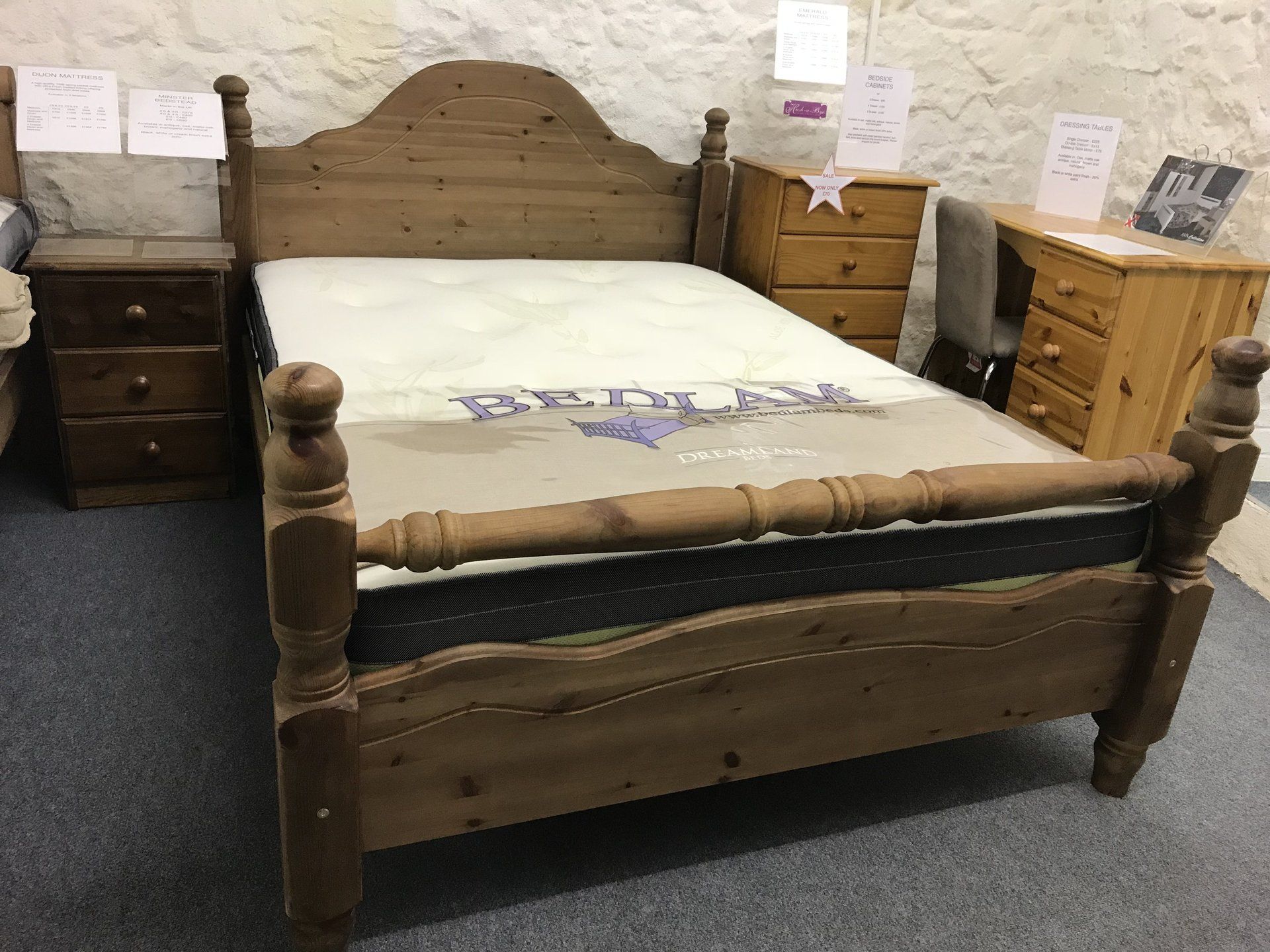 A wooden bed with a mattress on top of it in a bedroom.
