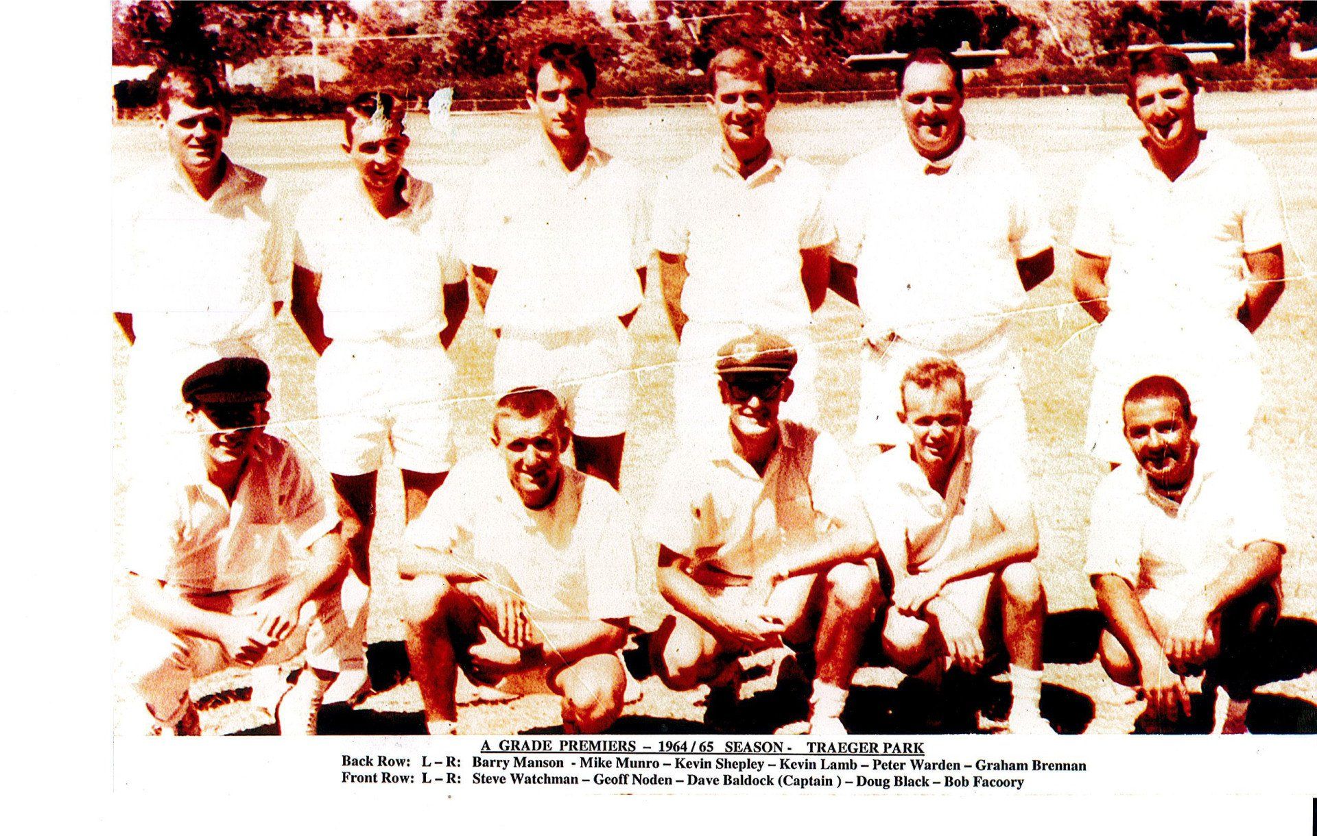 A group of men in white shirts are posing for a picture
