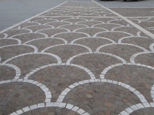 Vista frontale di un pavimento di originale progettazione in forma di vetri pasti che si sovrappongono in grigio e bianco