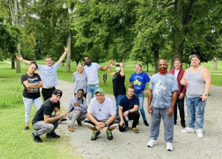 A group of people are posing for a picture in a park.