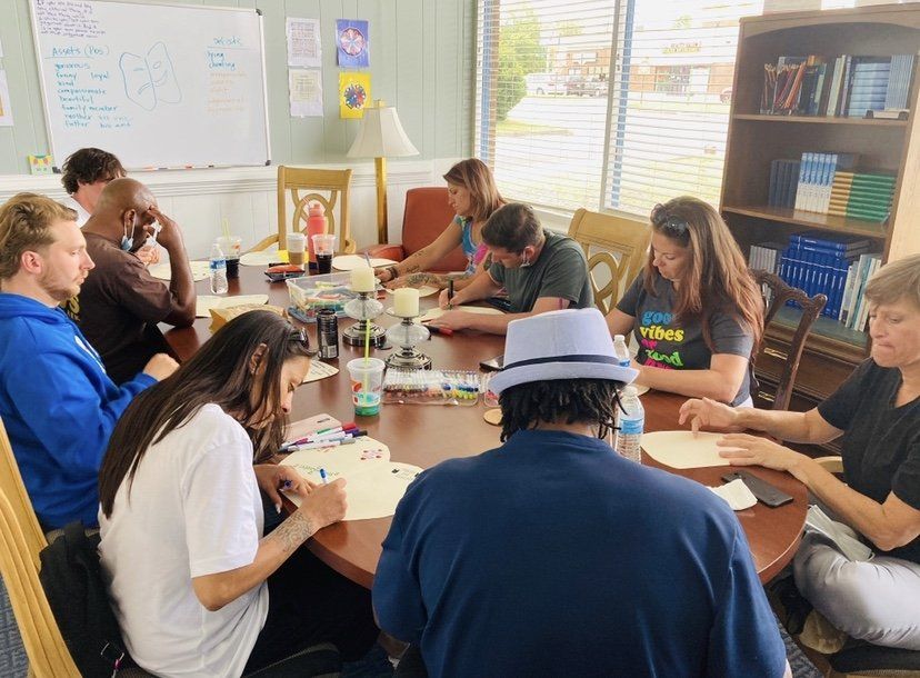 A group of people are sitting around a table in a room.
