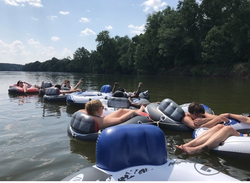 A group of people are floating on rafts on a lake.