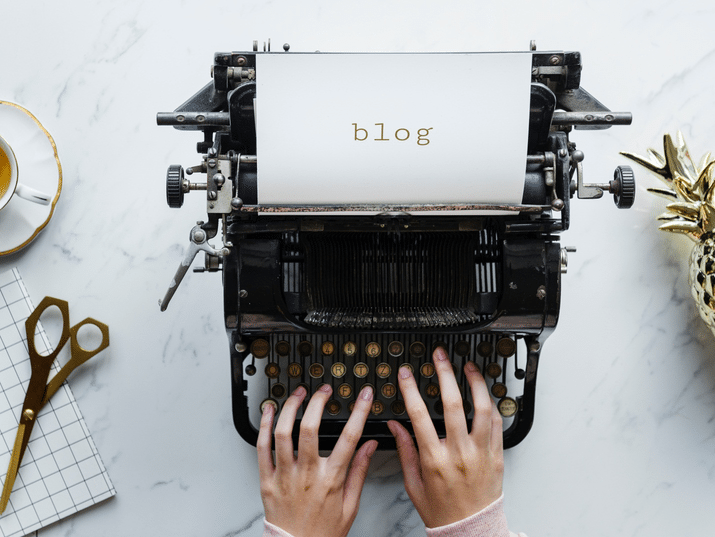 a person is typing on an old typewriter that says blog