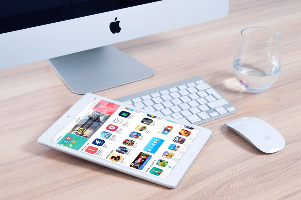 a tablet is sitting on a desk next to an apple computer
