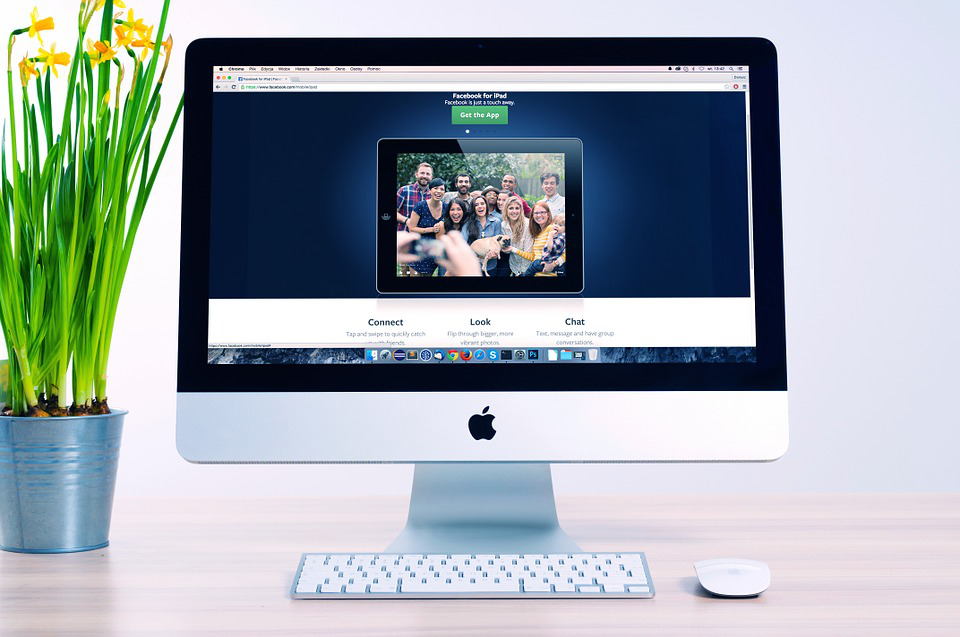an apple computer with a picture of a group of people on the screen
