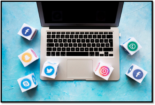 a laptop is surrounded by paper cubes with social media icons on them