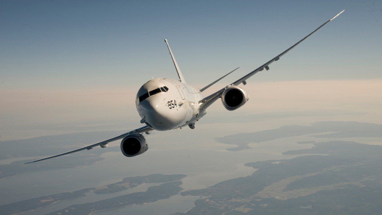 A large passenger jet is flying through a cloudy sky.
