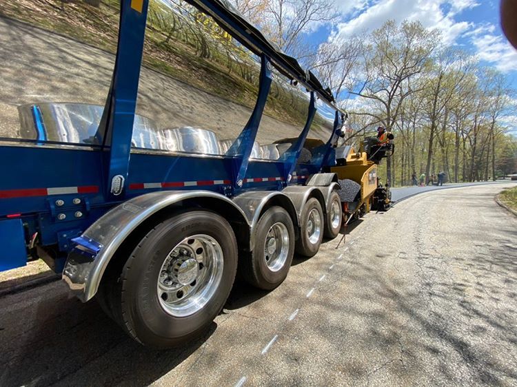 Trout River Industries Live Bottom unloading asphalt into a paver