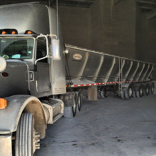 Trout River Industries Live Bottom trailer unloading Indoors