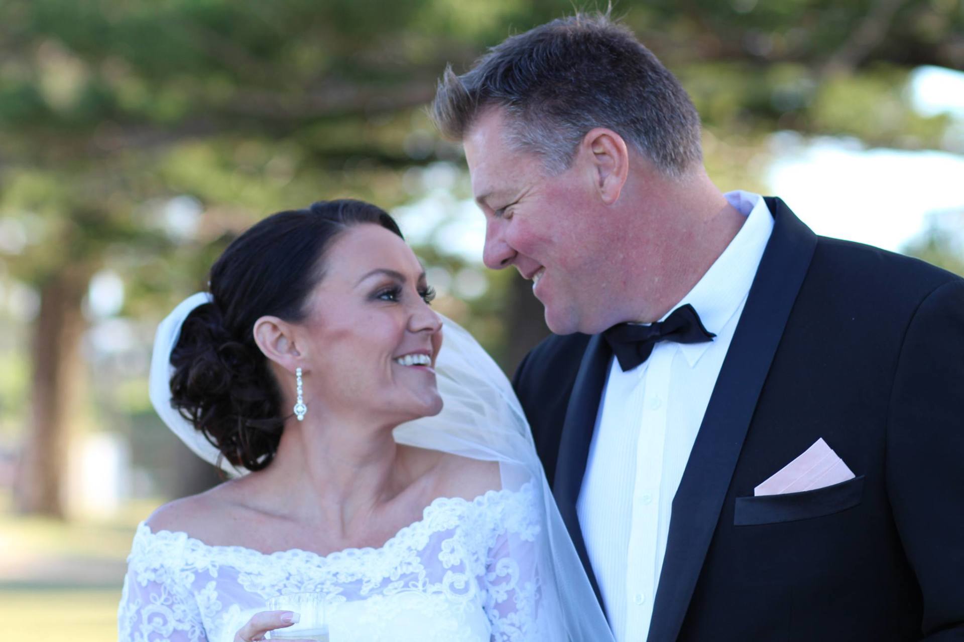 bridal couple about to kiss after their Sunshine Coast wedding at Dicky beach, groom in bow tie and evening dress, bride with veil