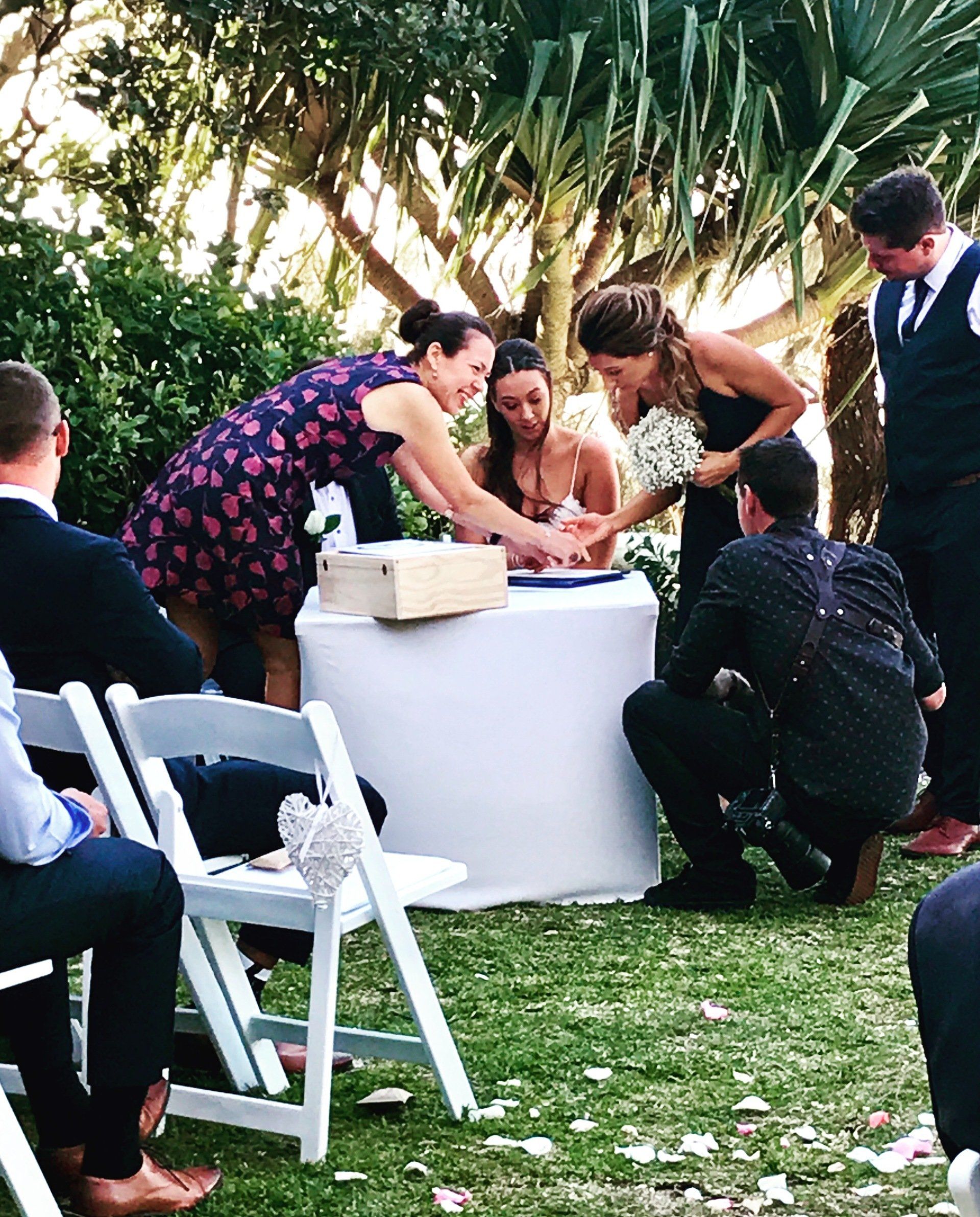 Noosa celebrant and Photographer with couple as they sign marriage certificates after their Noosa wedding