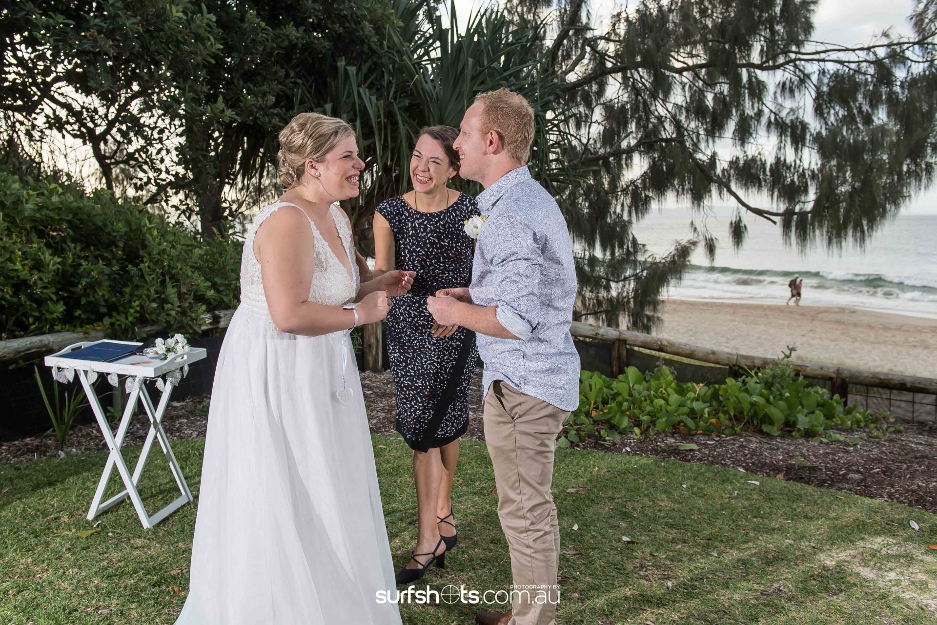 Noosa celebrant in navy dress calming eloping couple just before they marry  at sunset on beach