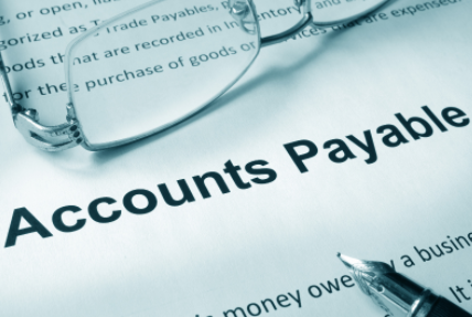Accounts payable form under eyeglasses and pen on a desk