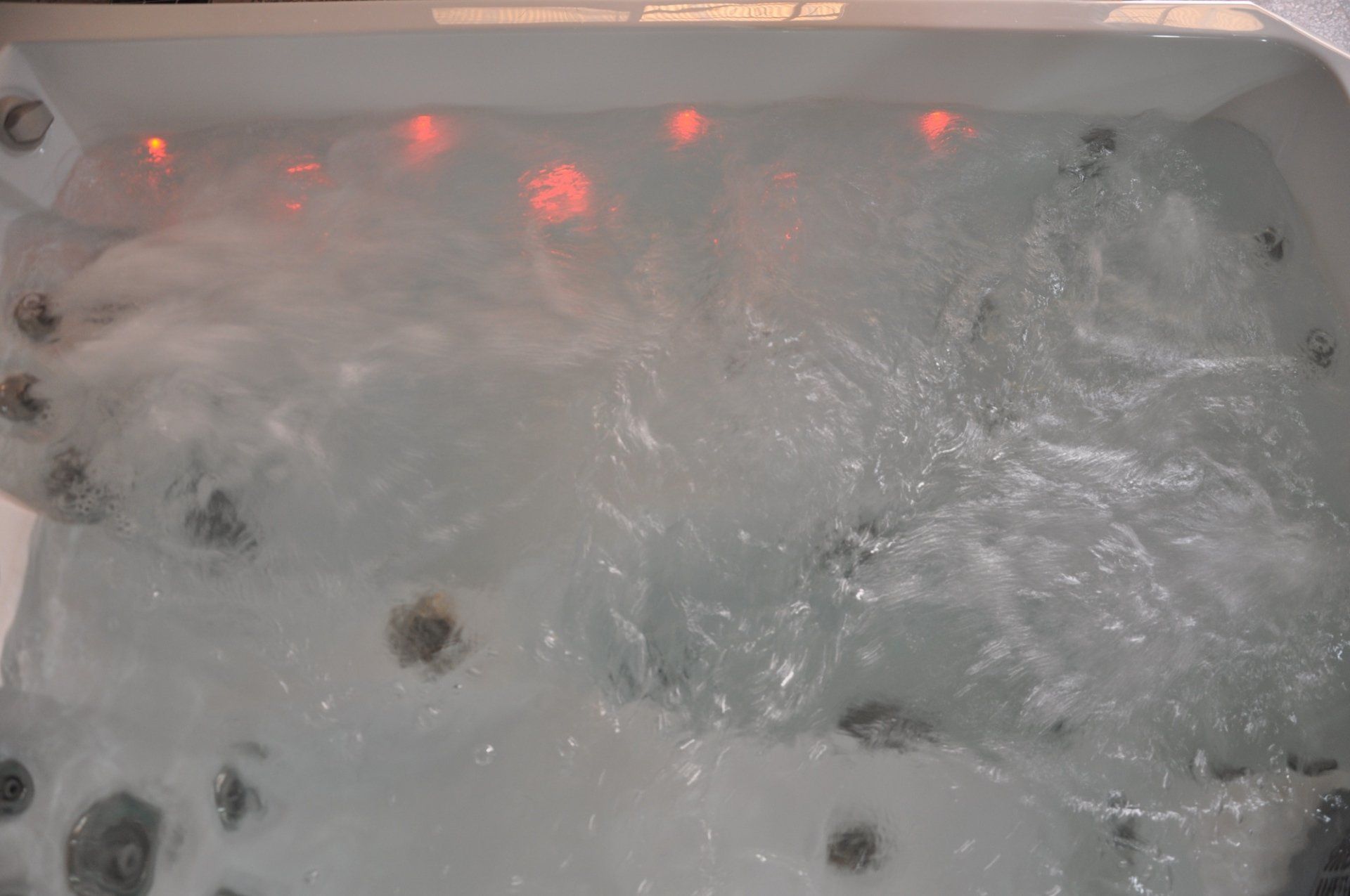 Un gros plan d'un jacuzzi rempli d'eau et de bulles.