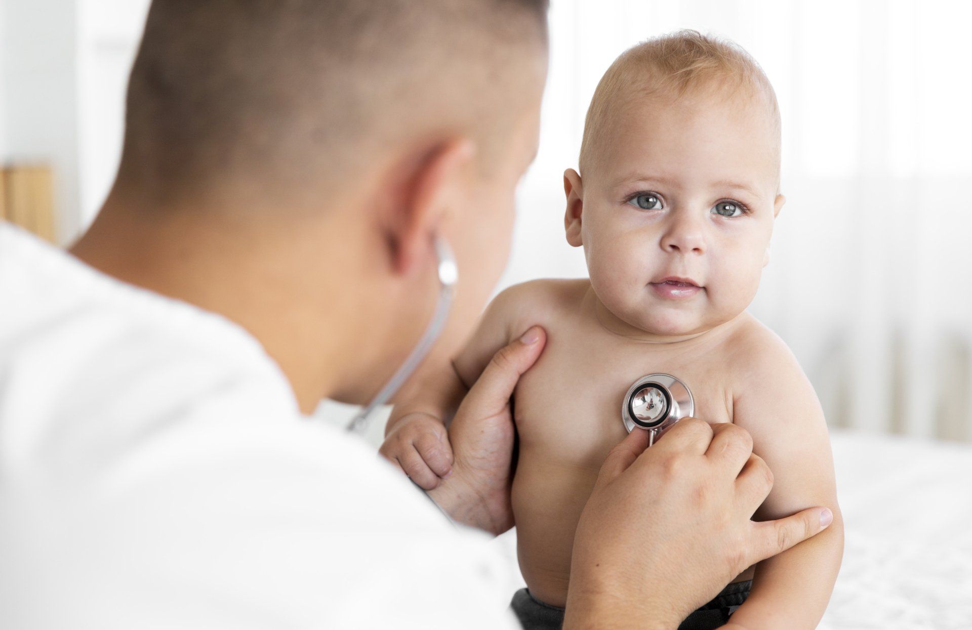 Un médico está escuchando el corazón de un bebé con un estetoscopio.