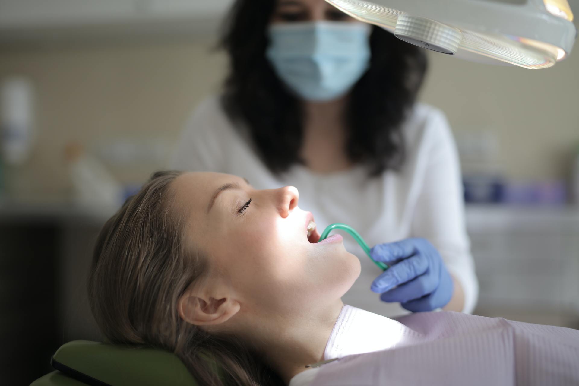 Una mujer está siendo examinada por un dentista.