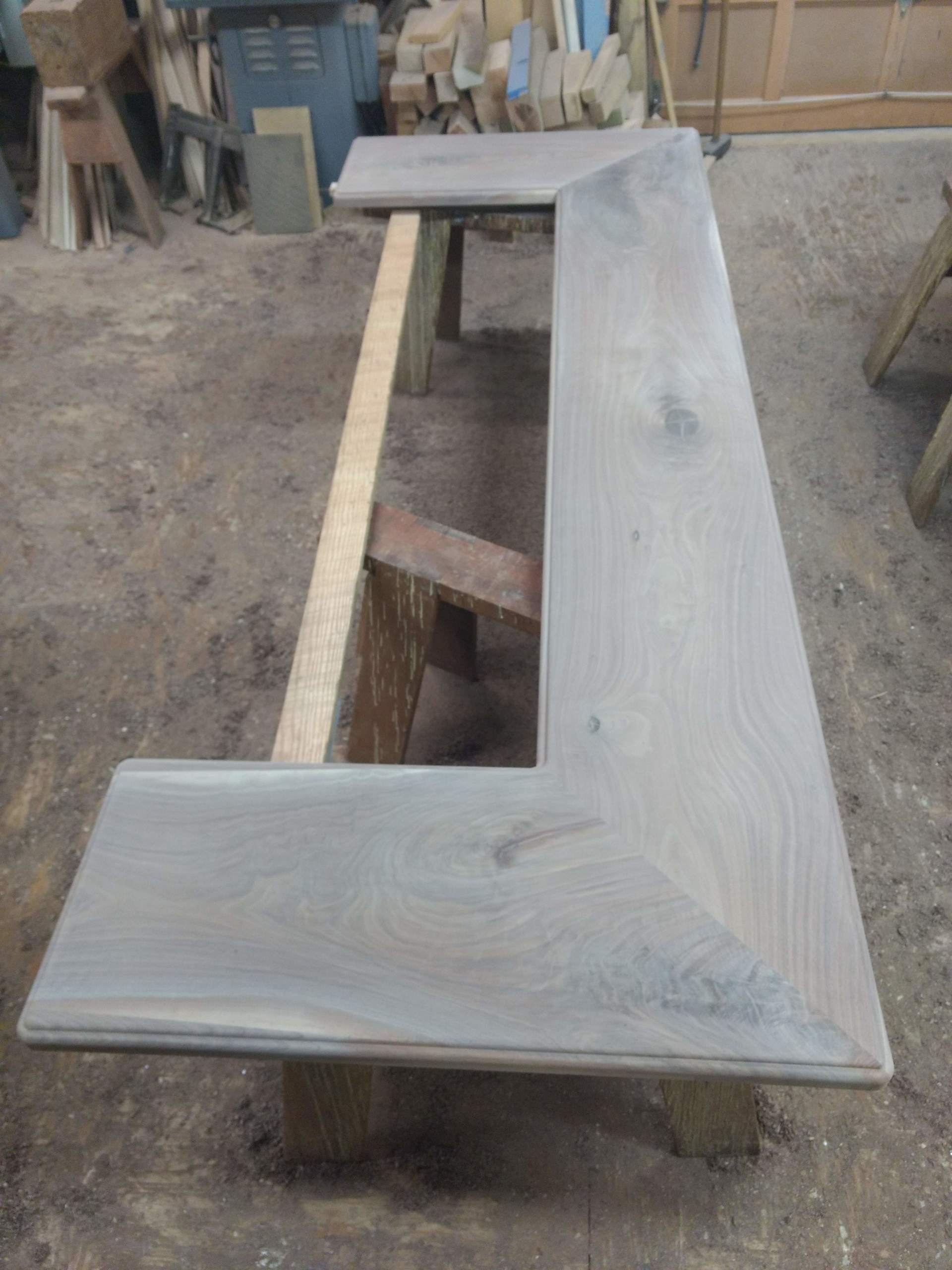 Wooden counter with angled edge in workshop setting.
