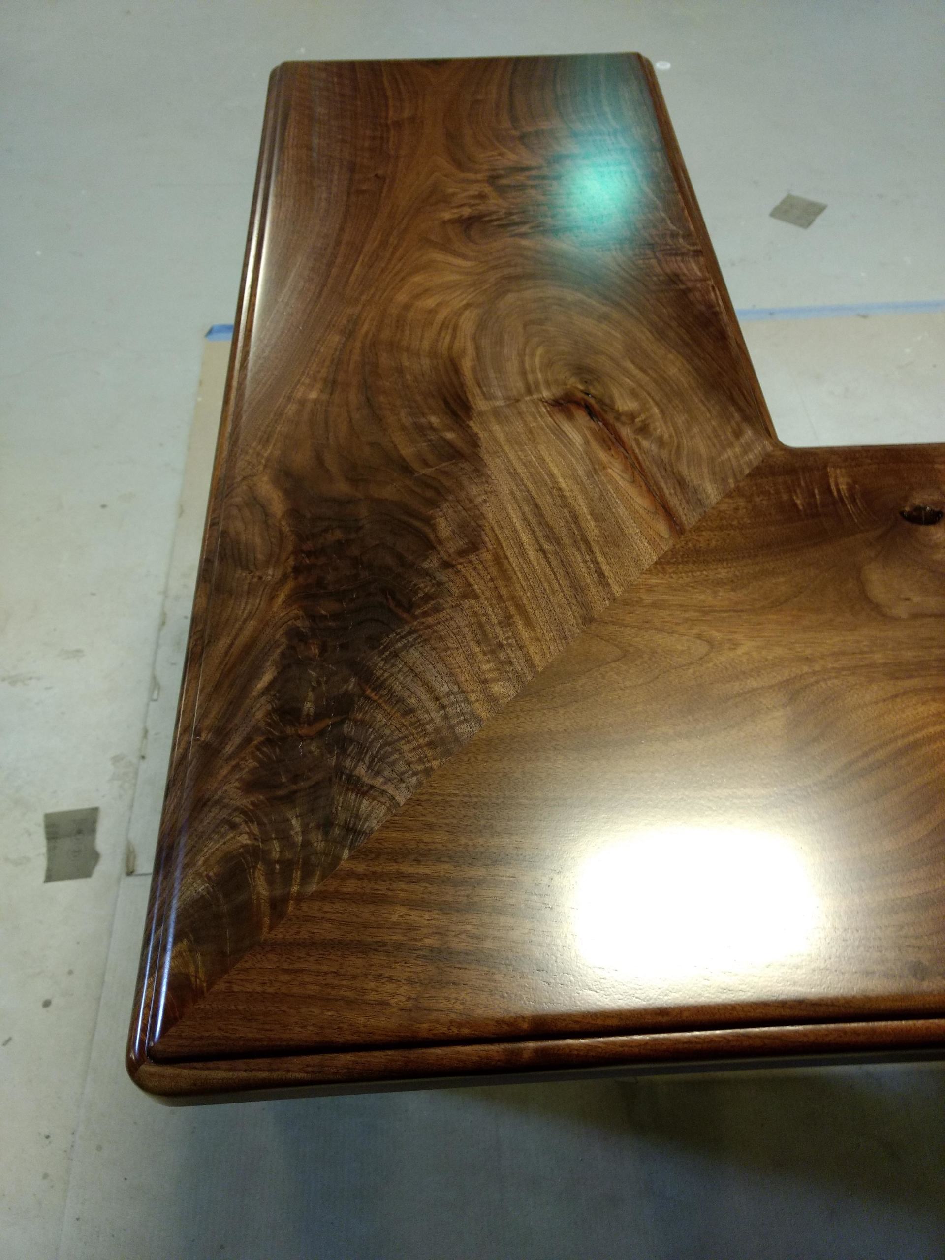 Dark wood, L-shaped countertop with a glossy finish.