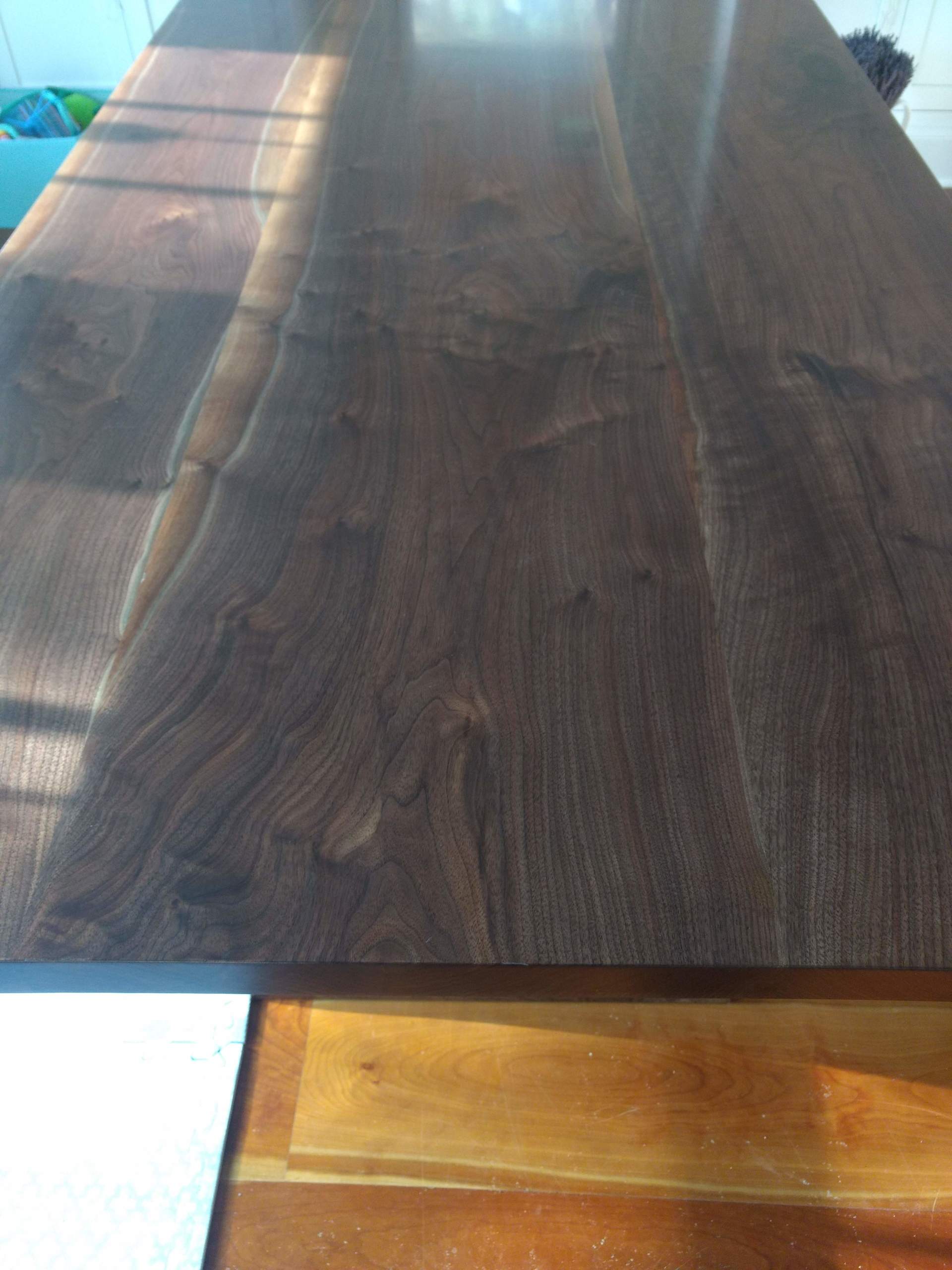Dark wood tabletop with prominent grain, partially in sunlight.