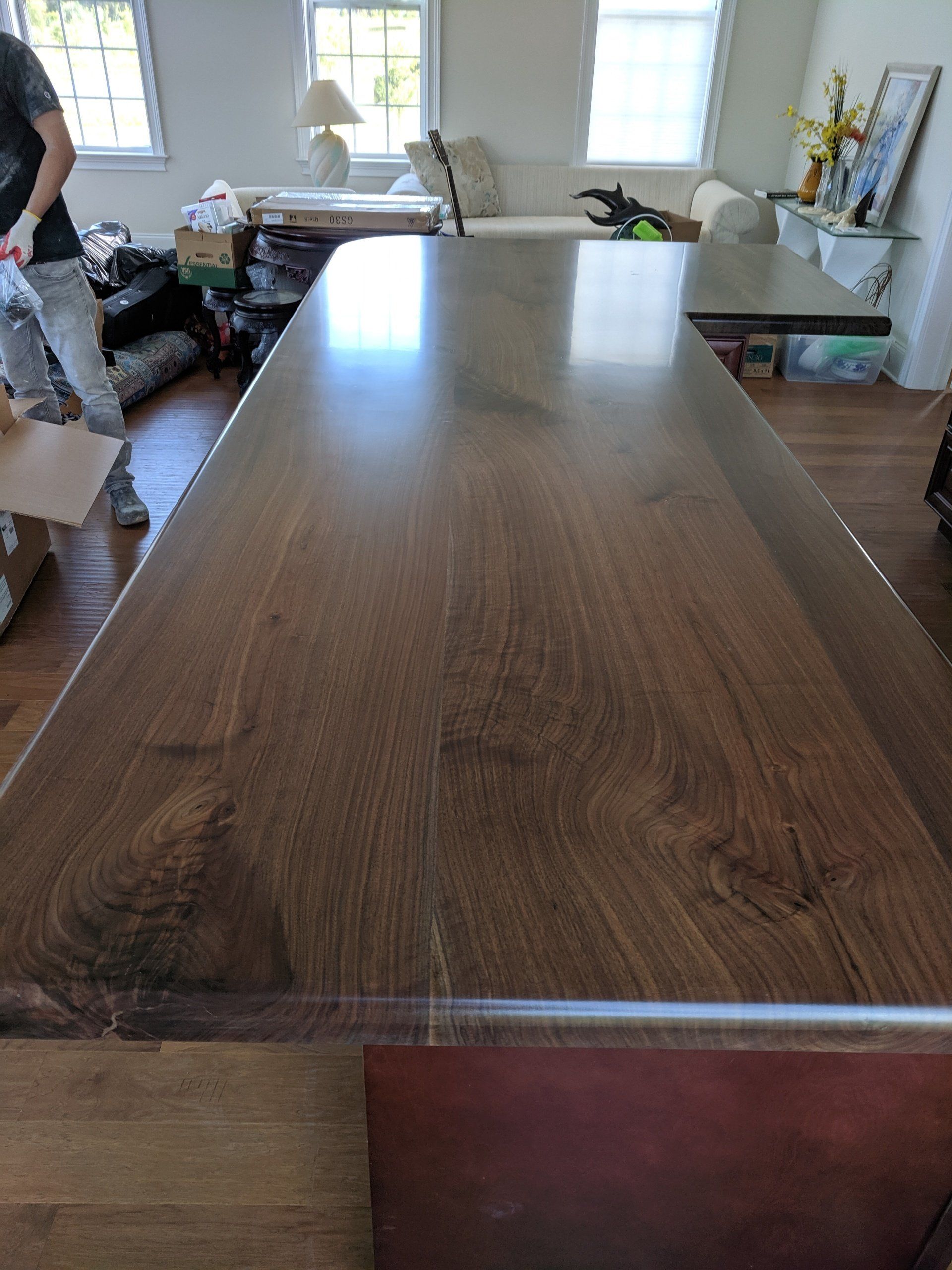 Dark wood countertop in a room; a person partially visible in the background.