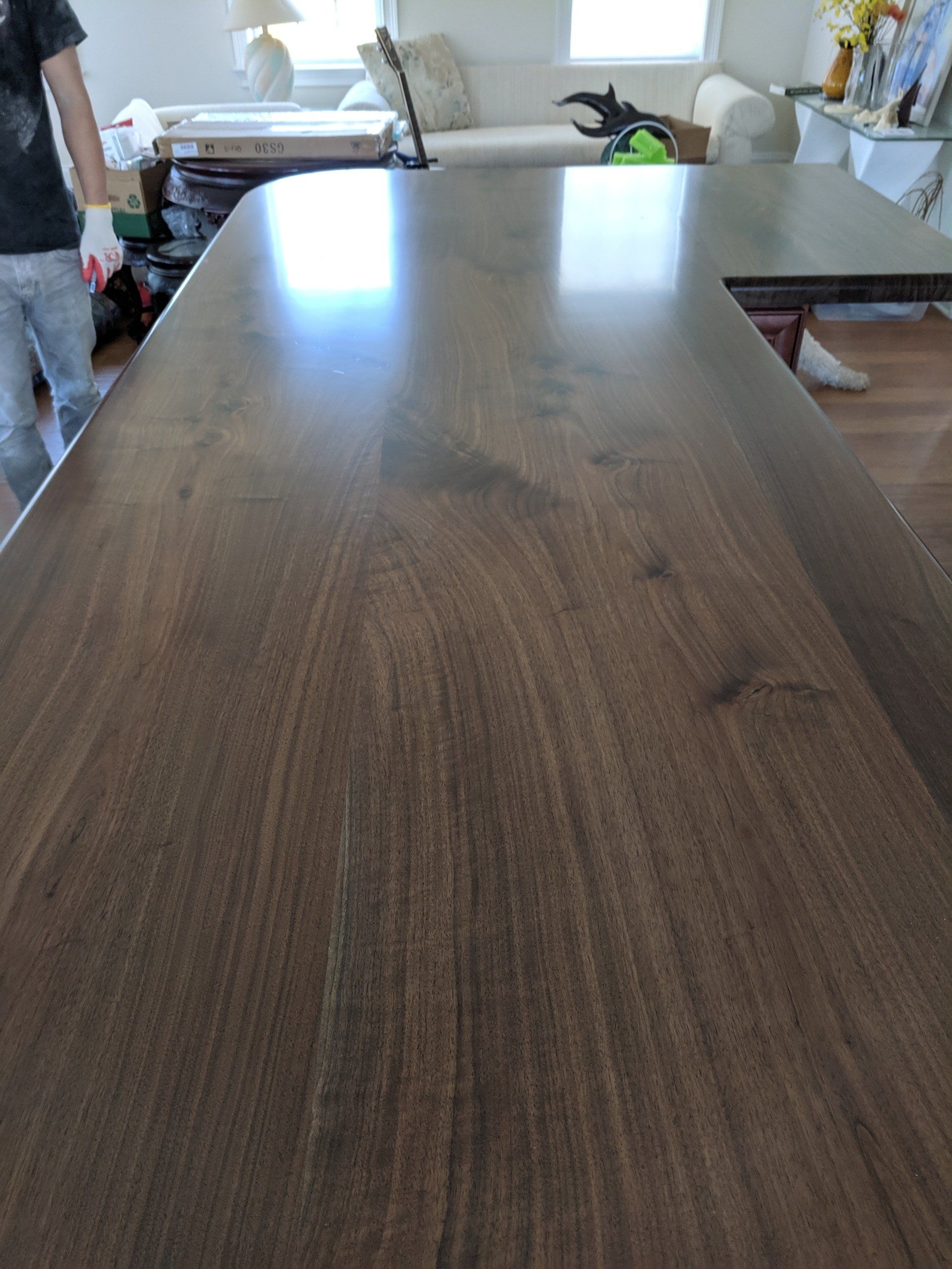 Dark wood countertop, person in background, reflective surface.