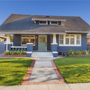 A blue house with a brick walkway leading to it