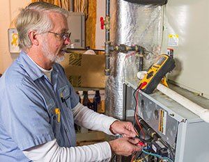 AC Repairs — Man Inspecting AC in Nashville, TN