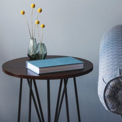 A small table with a book and vases on it