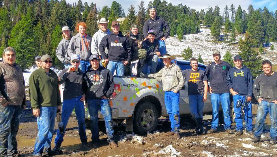 Brothers of Alpha Gamma Rho posing near a truck from a paintball event
