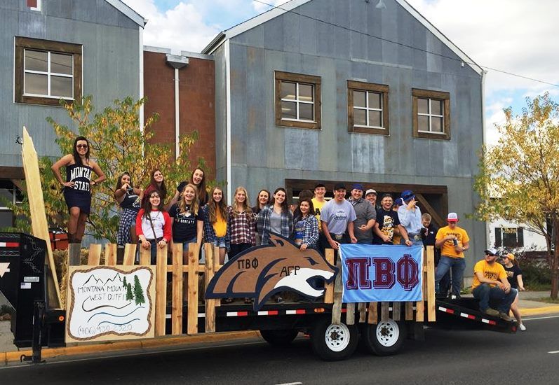 Alpha Gamma Rho and Pi Beta Phi homecoming float with brothers and sisters standing on top