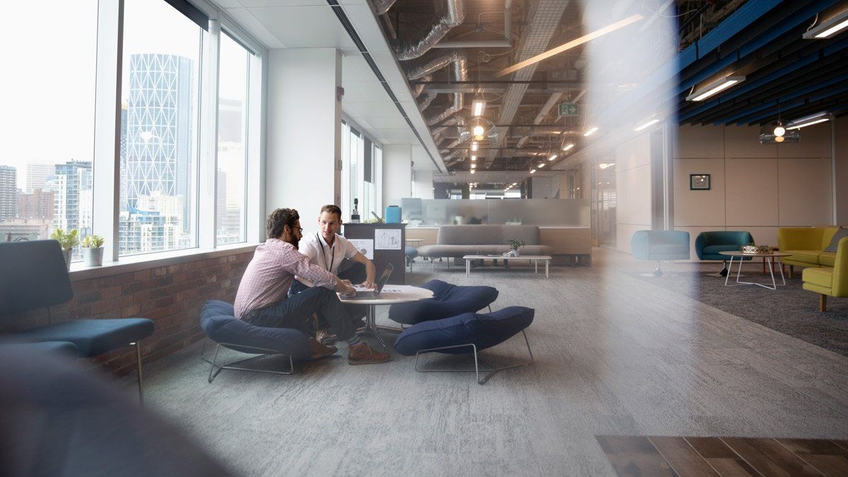 two men sitting at table in commercial building