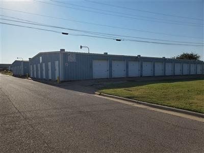 Exterior view of Woodway storage facility with multiple units, garage doors, and a paved road in front.