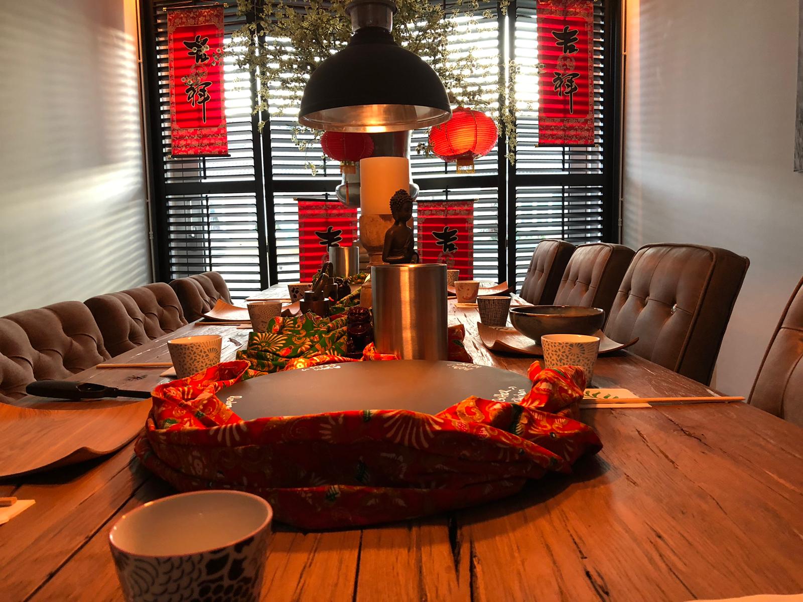 Eettafel gedekt voor een maaltijd, met rode Chinese decoraties .