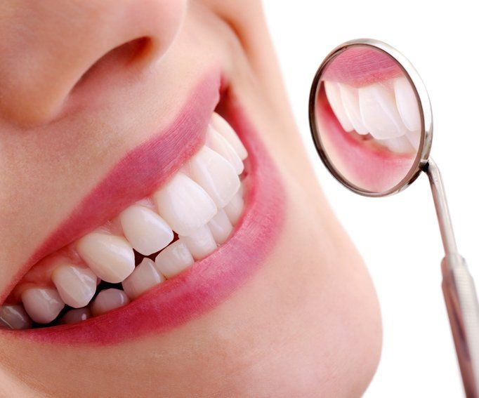Beautiful smiling model with dental mirror