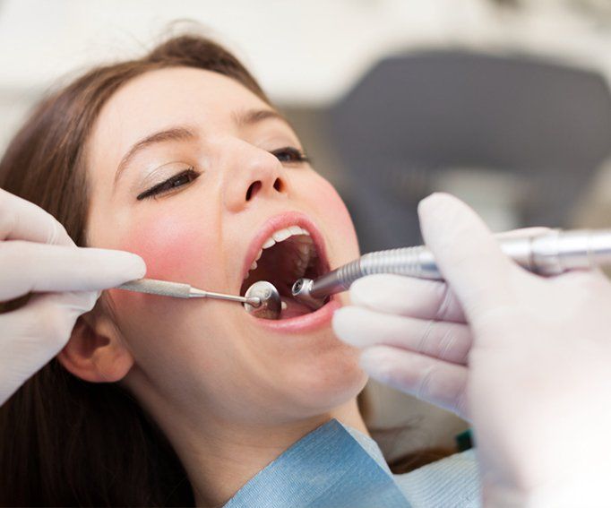 Dentist doing a dental treatment on a female patient
