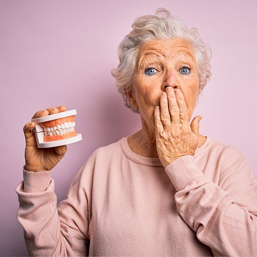 Woman Holding Plastic Denture Teeth — Sylacauga, AL — O'Brien Family Dentistry
