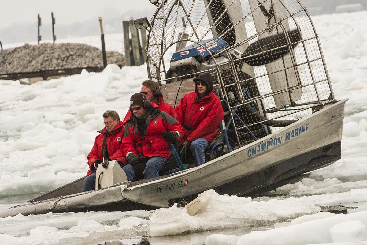 A group of people are sitting in a boat in the snow