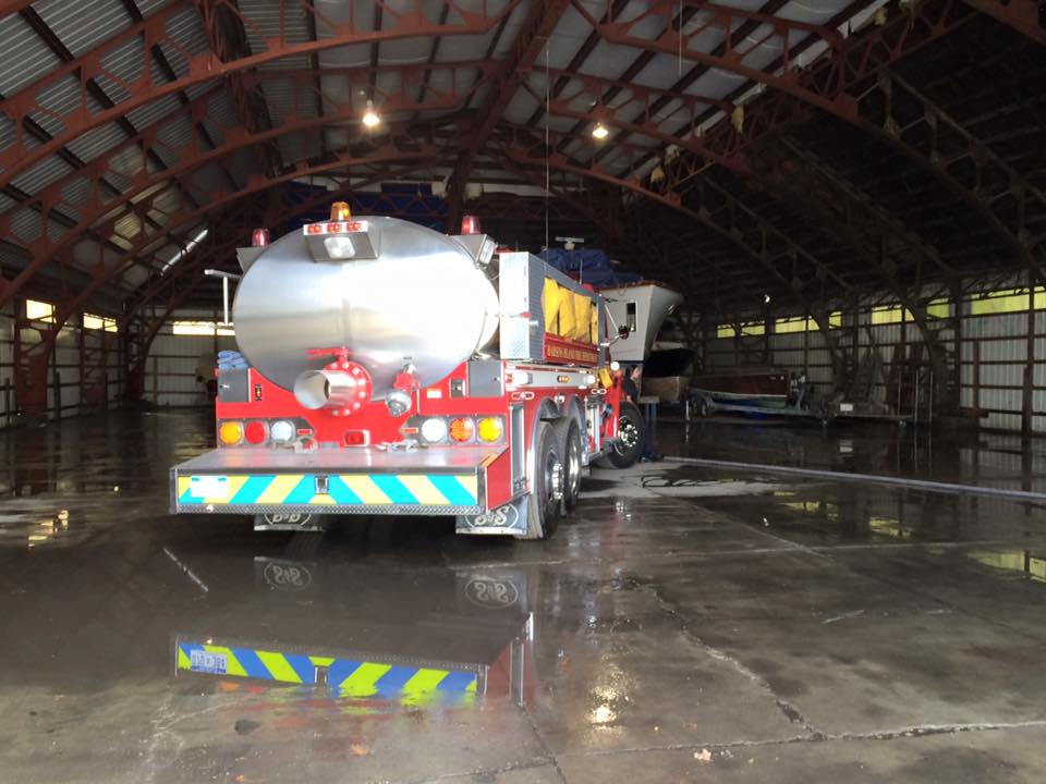 A large tanker truck is parked in a warehouse