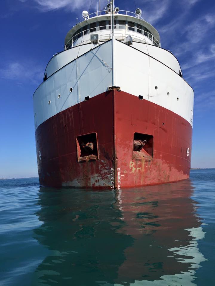 A large red and white ship is floating in the ocean