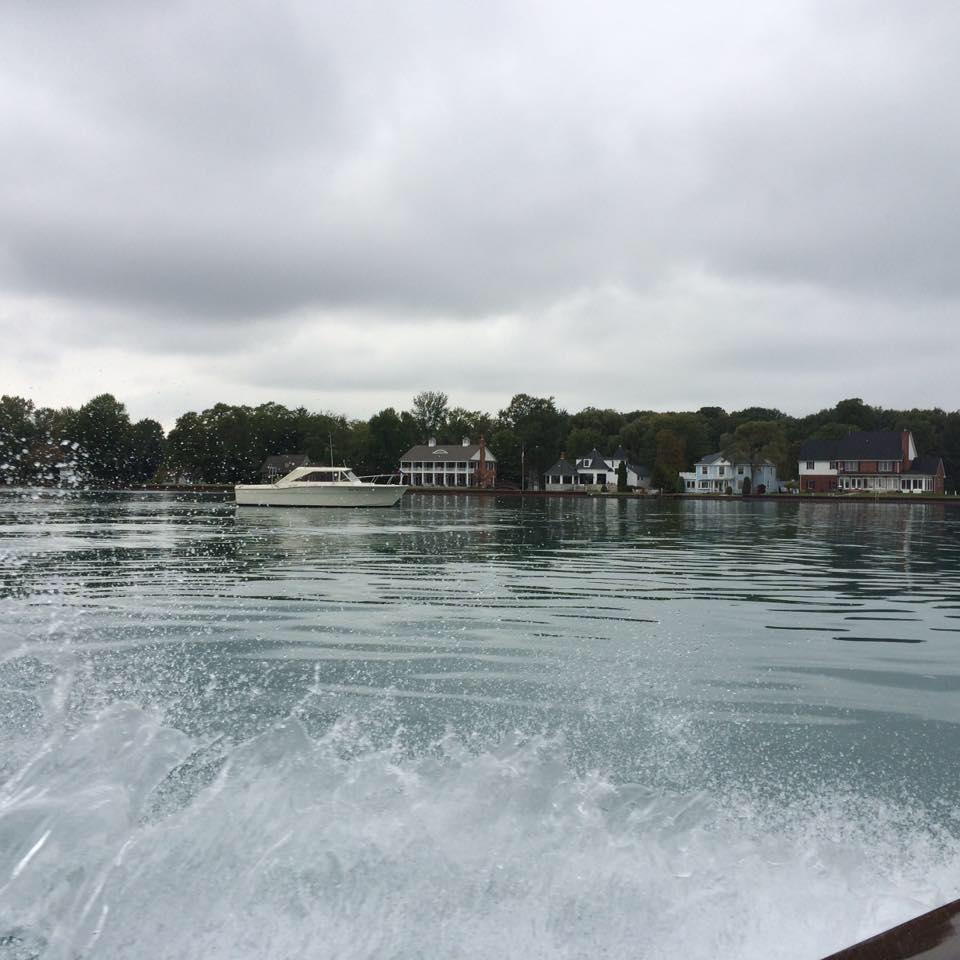 A boat is floating on a lake with houses in the background