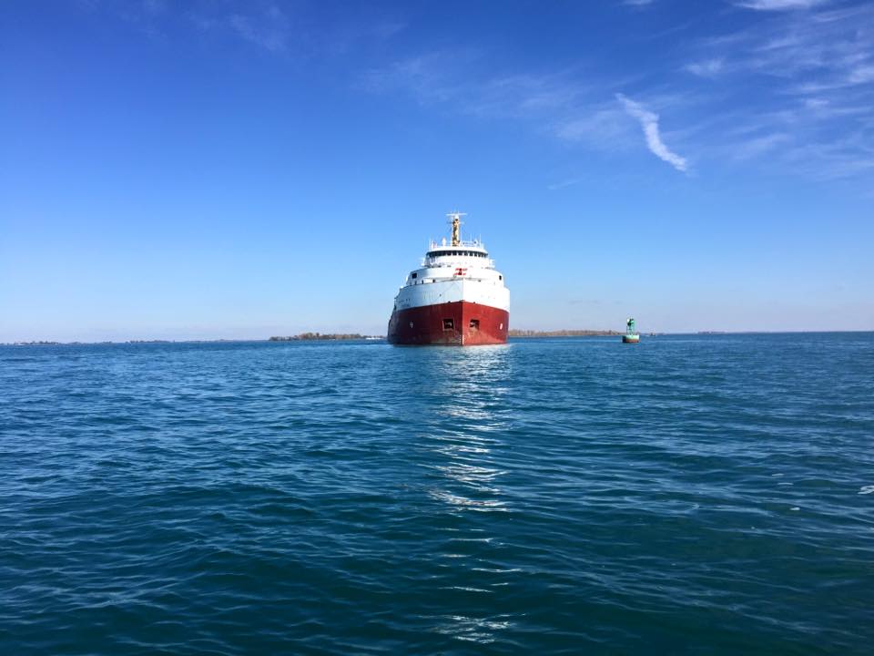 A large red and white ship is in the middle of the ocean