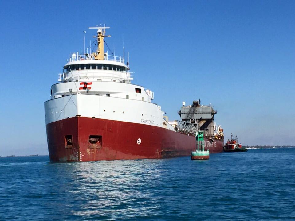 A large red and white ship is floating on top of a body of water