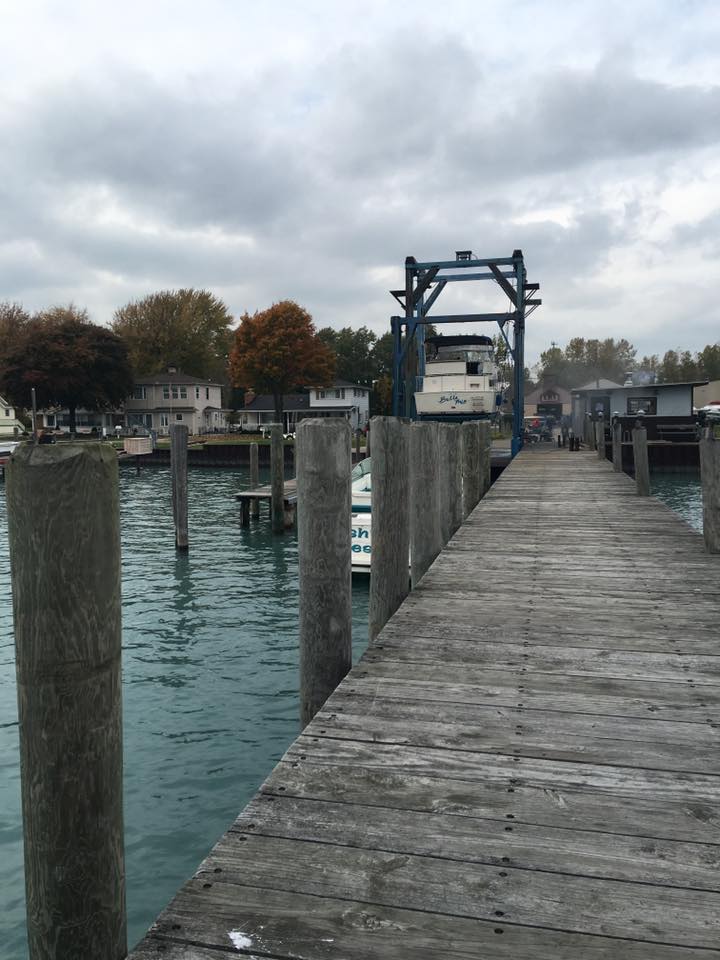 A wooden dock with a boat in the background